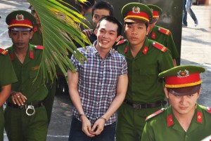 Police officer defendant Le Minh Phat escorted to the court (Pic: Tan Loc)